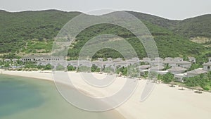 Luxury villas and mansions with swimming pools on sea shore on green mountains and blue water landscape. Resort hotels