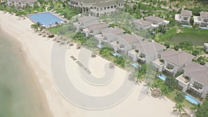 Luxury villas in resort hotel with swimming pool on tropical island at sea shore. Aerial view swimming pool in resort