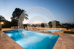 Luxury water pool and garden with dining area at night