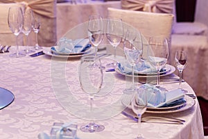 Luxury wedding arrangement of stylish glasses plates on napkins