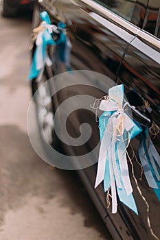 Luxury wedding car decorated with white and blue ribbons