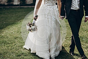 Luxury wedding couple holding hands and walking. stylish groom a