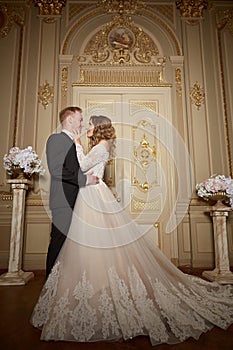 Luxury wedding couple in love. Beautiful bride in white dress with brides bouquet and handsome groom in black suit