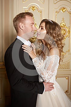 Luxury wedding couple in love. Beautiful bride in white dress with brides bouquet and handsome groom in black suit