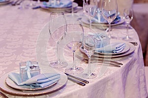 Luxury wedding reception. stylish glasses, plates on napkins and