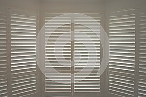 Luxury white indoor plantation shutters, closed shutters photo
