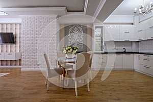 Luxury white modern kitchen with rose walls in studio apartment