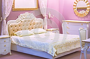 Luxury white and pink bedroom in antique style with rich decor . Interior of a classic style bedroom in luxury apartment