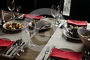 Luxury wine glasses and silver tableware near plates with red na