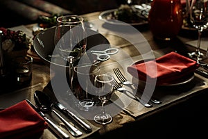 Luxury wine glasses and silver tableware near plates with red na