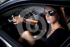 Luxury woman with long legs sitting in the car