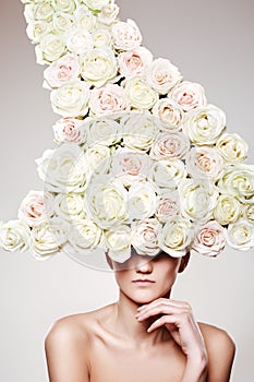 Luxury woman with a rose hat in fashion model pose