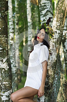 Luxury woman in shirt standing near the birches