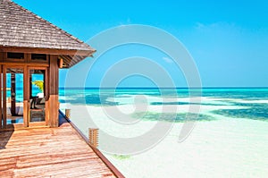 Luxury wooden house on stilts on the background of azure water and beautiful sunny sky