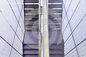 Luxury wooden staircase with glass railing and gold handrail in golden grille house interior