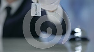 Luxury written on keychain in receptionist hand, premium quality hotel, closeup