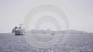 Luxury yacht cruising out at sea. Action. Aerial view of luxury yacht and cruise ship pm rippling water surface.
