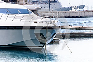 Luxury yacht docked in sea port. Marine parking of modern motor boats and blue water.