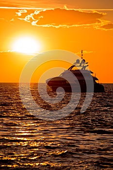 Luxury yacht on open sea at golden sunset