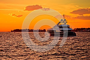 Luxury yacht on open sea at golden sunset