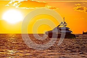 Luxury yacht on open sea at golden sunset