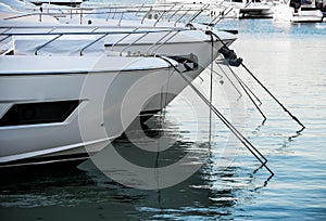 Luxury yachts docked in sea port at sunset. Marine parking of modern motor boats and blue water