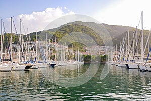 Luxury yachts docked in sea port at sunset. A stunning view of mega yachts in the port. Mountains background.