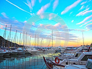 Luxury yachts and sailboats in seaport at sunset. Marine parking of modern motor boats in Liguria, Italia