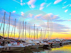 Luxury yachts and sailboats in seaport at sunset. Marine parking of modern motor boats in Liguria, Italia