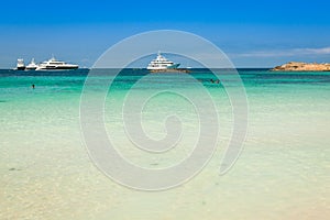 Luxury yachts in turquoise beach of Formentera Illetes