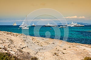 Luxury yachts in turquoise beach of Formentera Illetes