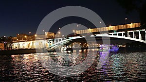 Luzhnetskaya Bridge (Metro Bridge) and Tourist pleasure boat on the Moskva River at night, Moscow, Russia