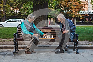 Lviv, Ukraine - August 3, 2019 - seniors playing chess at city bench park