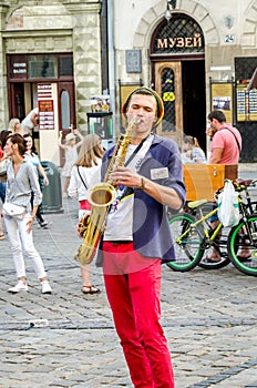 Lviv, Ukraine - July 2015: The musician plays the saxophone giving a concert in the Market Square in Lviv before the audience