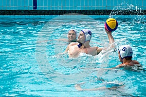 Lviv, Ukraine - July 2015: Ukrainian Cup water polo. Athlete team's water polo ball in a swimming pool and makes attacking shot on