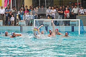 Lviv, Ukraine - July 2015: Ukrainian Cup water polo. Athlete team's water polo ball in a swimming pool and makes attacking shot on