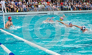 Lviv, Ukraine - July 2015: Ukrainian Cup water polo. Athlete team's water polo ball in a swimming pool and makes attacking shot on