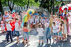 Lviv, Ukraine - July 2015: Yarych street Fest 2015. Clown and Indian play, sing and dance with the children in the park