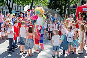 Lviv, Ukraine - July 2015: Yarych street Fest 2015. Clown and Indian play, sing and dance with the children in the park