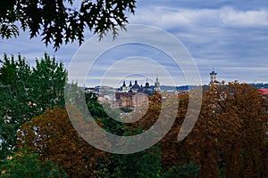 Lviv Ukrainian autumnal city panoramic view from top point with foreground October trees brown and green foliage natural outdoor