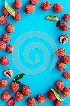 Lychee frame. Exotic asian fruits on blue background top-down copy space