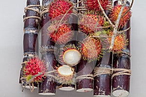 Lychee peeled showing the red skin and white flesh.