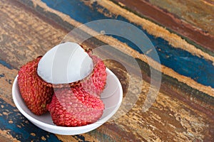 Lychee on white plate on table photo