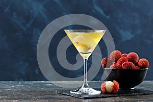 Lychees drink and fruit on dark background