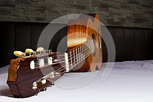 Lying classic guitar in front of a stone wall