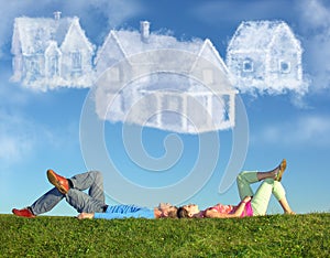 Lying couple on grass and dream three cloud houses