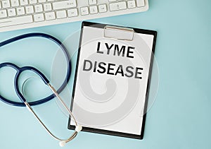 Lyme Disease text on paper with heart beat diagram, stethoscope, delicious green apple, measurement tape and blue dumbbell on