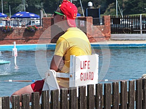 Lymington, England - July 2013: A lifeguard watches bathers in public swimming pool