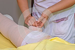 Lymphedema management: Wrapping leg using multilayer bandages to control Lymphedema. Part of complete decongestive therapy cdt a