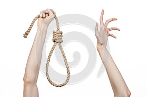 Lynching and suicide theme: man's hand holding a loop of rope for hanging on white isolated background